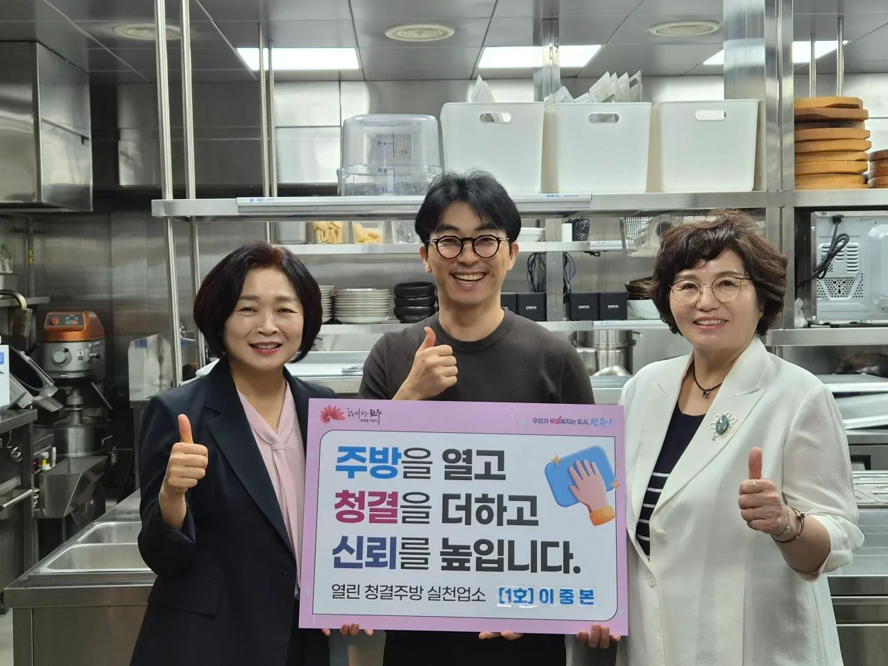 이중본 주방에서 열린 청결주방 실천업소 피켓을 들고 기념 촬영하는 관계자들